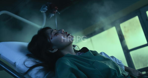 High Resolution: Asian woman with long black hair lying on her back in a dim hospital room illuminated by greenish light wearing teal scrubs with blood smeared across one cheek download. | HRJPG.com