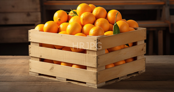 High Resolution: Wooden crate filled with bright orange glossy-skinned oranges some with green leaves attached against a dark background and a weathered table surface download. | HRJPG.com