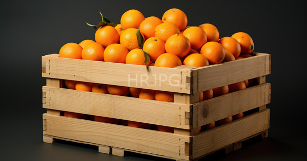 High Resolution: Wooden crate filled with bright orange oranges some still attached to green stems stacked against a dark gray background in a studio setting download. | HRJPG.com