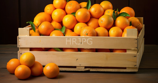 High Resolution: Wooden crate filled with bright orange textured citrus fruits some with green leaves attached with four additional oranges in front on a dark wood surface download. | HRJPG.com