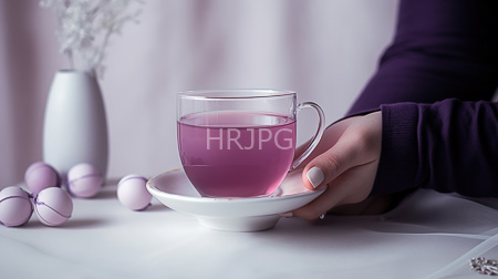 High Resolution: Elegant minimalist scene featuring a hand with manicured nails holding a clear glass teacup filled with pink liquid on a white saucer download. | HRJPG.com