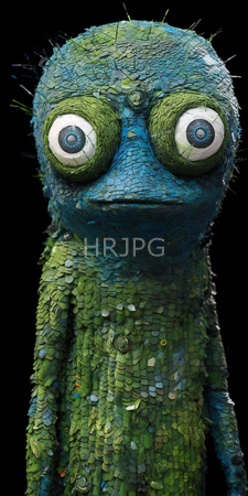 High Resolution: Intricately textured blue-green chameleon-like puppet with large white eyes and green scales against black background download. | HRJPG.com