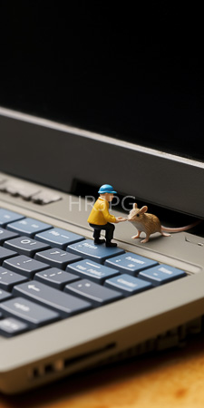 High Resolution: Two small figurines on an open laptop keyboard; one resembling a construction worker extending his hand to pet a figure that resembles a brown mouse download. | HRJPG.com
