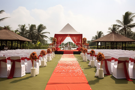 High Resolution: Outdoor wedding setup featuring white chairs with red sashes adorned by orange flower arrangements download. | HRJPG.com