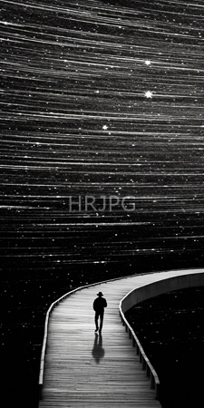 High Resolution: Black-and-white solitary figure curved wooden boardwalk gazing at starry night sky with horizontal streaks scattered stars reflective surface download. | HRJPG.com