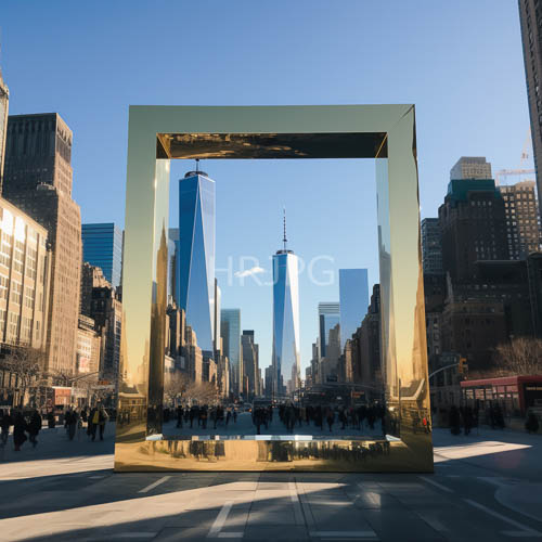 large gold rectangular sculpture dominates urban plaza with nyc skyline