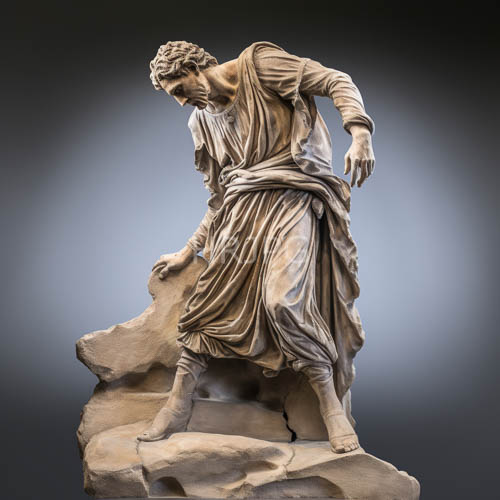 coiled marble statues rest on fractured rock in draped robes