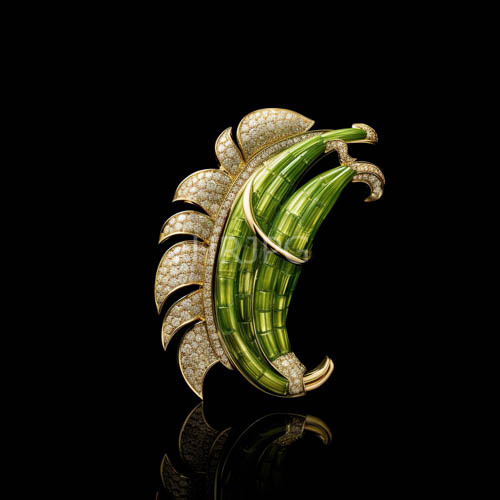 emeraldgreen brooch with intricate jadelike textures and delicate diamondstudded wings against a stark black background
